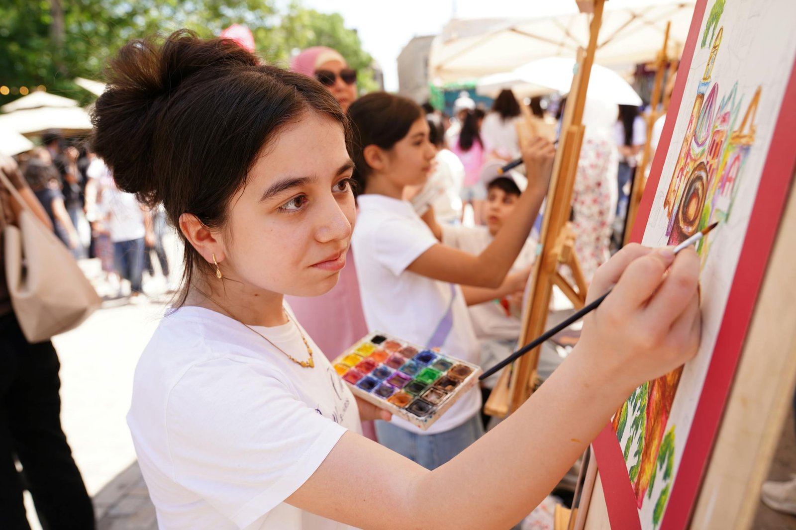 teenagers engage in artistic expression by painting outdoors showcasing creativity and teamwork. 33029254 chitra bina